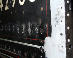 The left hand lower cabside is to be removed to allow below-floor access, so the many rivets securing it need to be drilled out – carefully to avoid damage to the sidesheet. Note the round-headed setscrews securing the angle panel to the sidesheet, still in white paint.