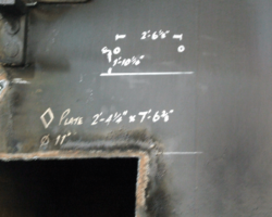 Corroded steel is being cut out, and the dimensions for the new metal chalked on the front plate.