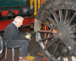 SMF member Alan Moody relaxing as he chips old paint from the left hand trailing driving wheel.