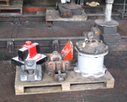 Parts laid out for display. From the left at the back is the pattern for the new spring hanger brackets, an old brake hanger bracket, the bracket for the reverser balance spring, refurbished steam brake cylinder; at the front left is a new spring hanger bracket with an old one to its right.