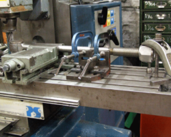 These are new spring hangers being worked on in the machine shop. The heads must be ground down so as to fit within the brackets, as seen in previous updates. This is done initially by milling, as here, but will be finished by hand grinding.