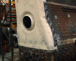 In the boiler shop, the job of fitting the outer backplate goes on.