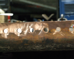 The flange’s top face with the drilled holes in close up.