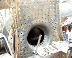 The copper inner backplate, which has been the recipient of much welding, has been removed from the welding bay prior to fitment once all riveting on the outer shell is finished.